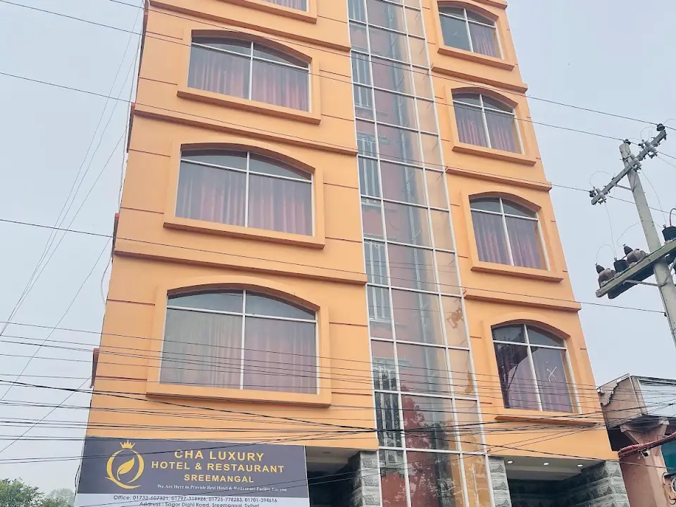 Cha Luxury Hotel & Restaurant's orange multi-storey building with its ground-floor signboard giving the address and phone numbers