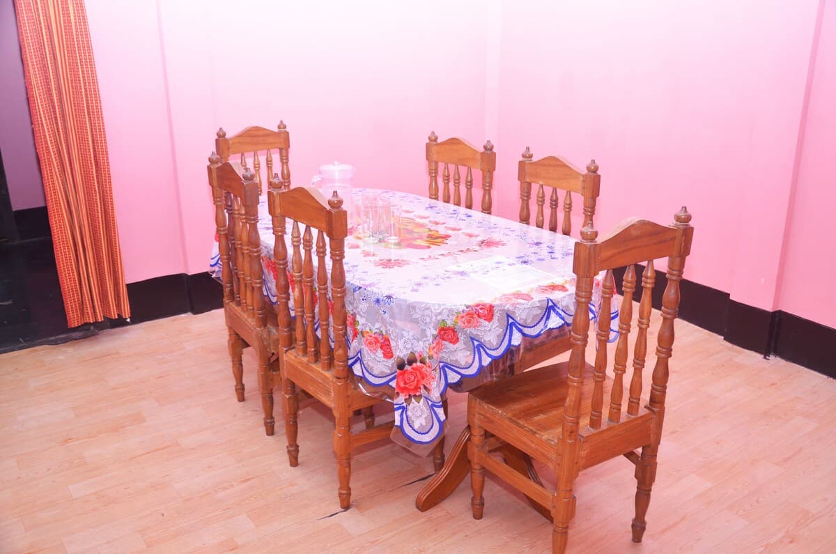 Dining room with a wooden table set for six under pink walls