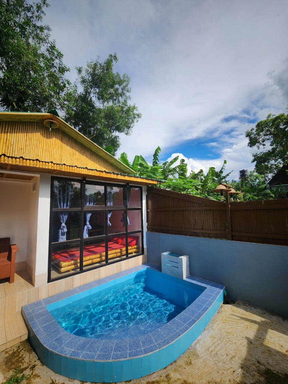A private-pool villa at Nirjon Nature's Hideout with a bamboo roof, glass-walled bedroom, and a small tiled plunge pool