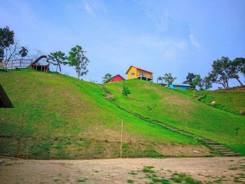 Colourful cottages at Pangan Resort atop a green hillside
